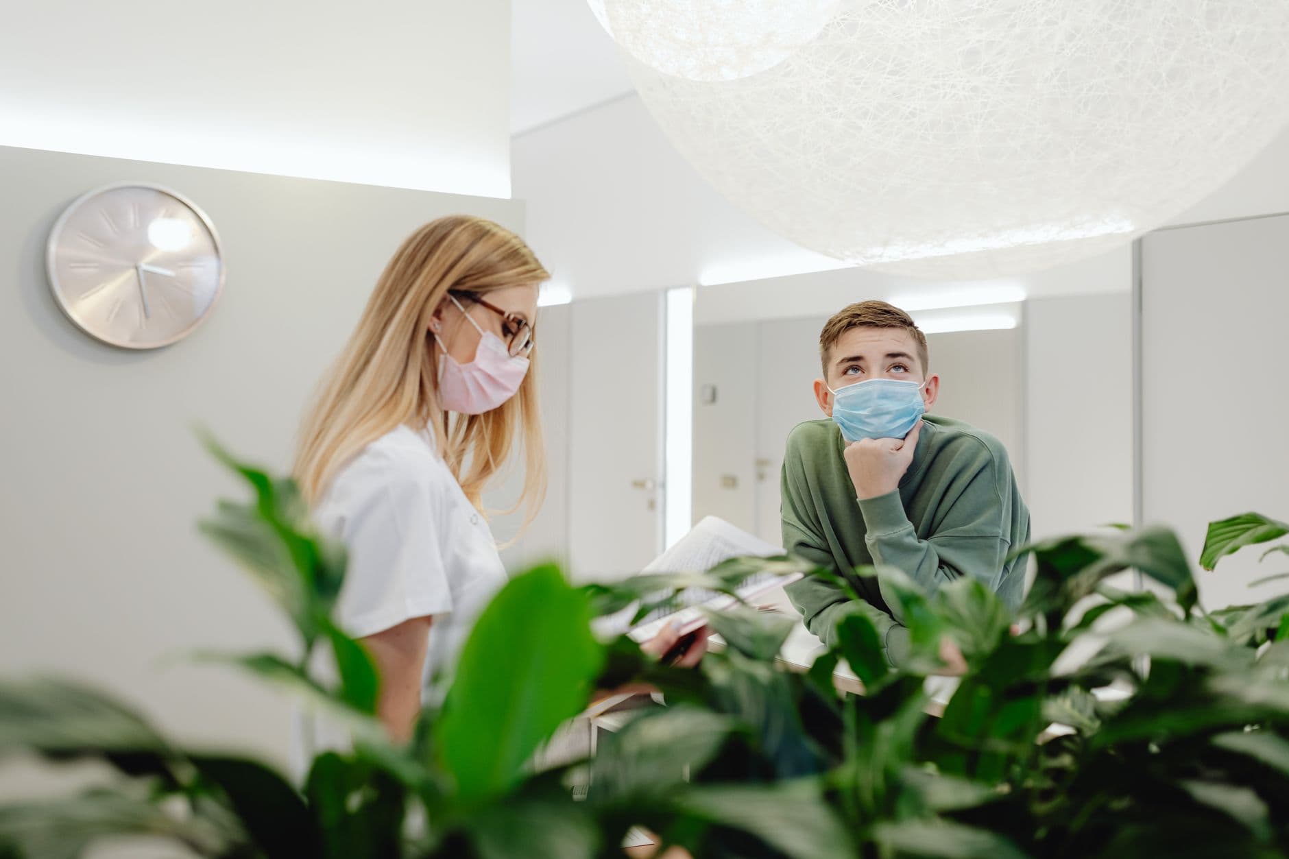 Clinic & Hospital Appointment Websites — Nurse and patient wearing face masks in a modern clinic, enhancing safety.