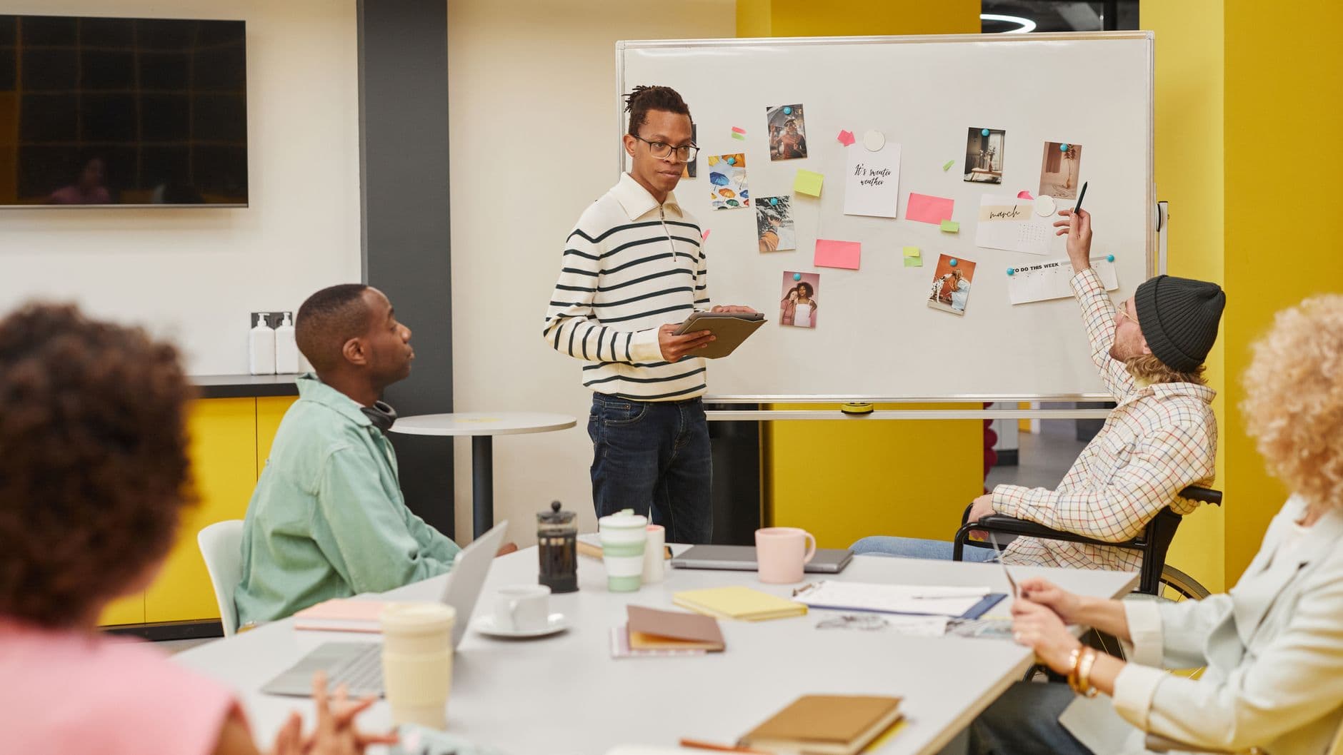 Cloud Hosting for Digital Agencies — A diverse team engaged in a collaborative meeting around a whiteboard in a modern office setting.