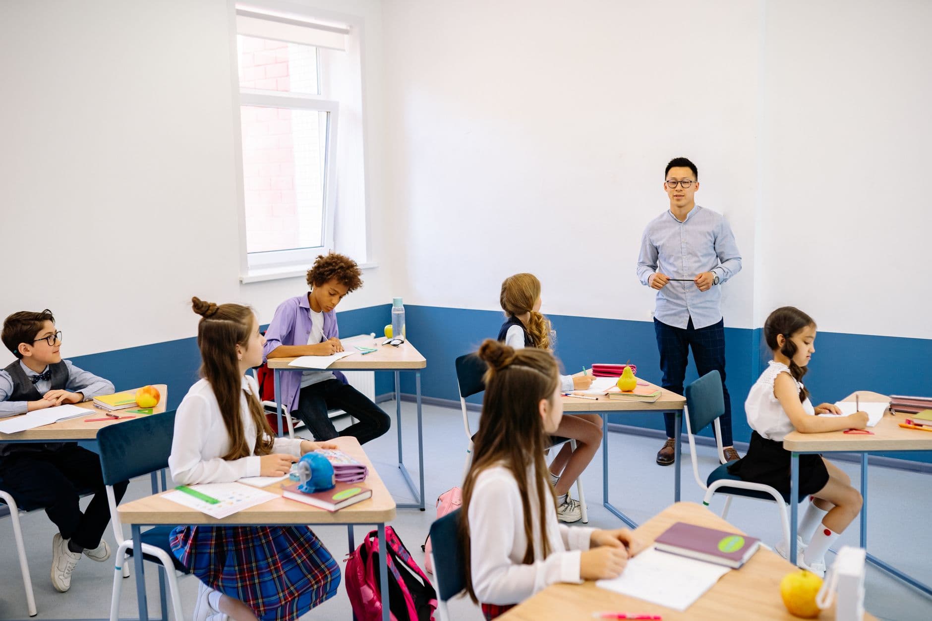 Coaching Institute Websites — Teacher instructing a diverse group of elementary students in a modern classroom setting.