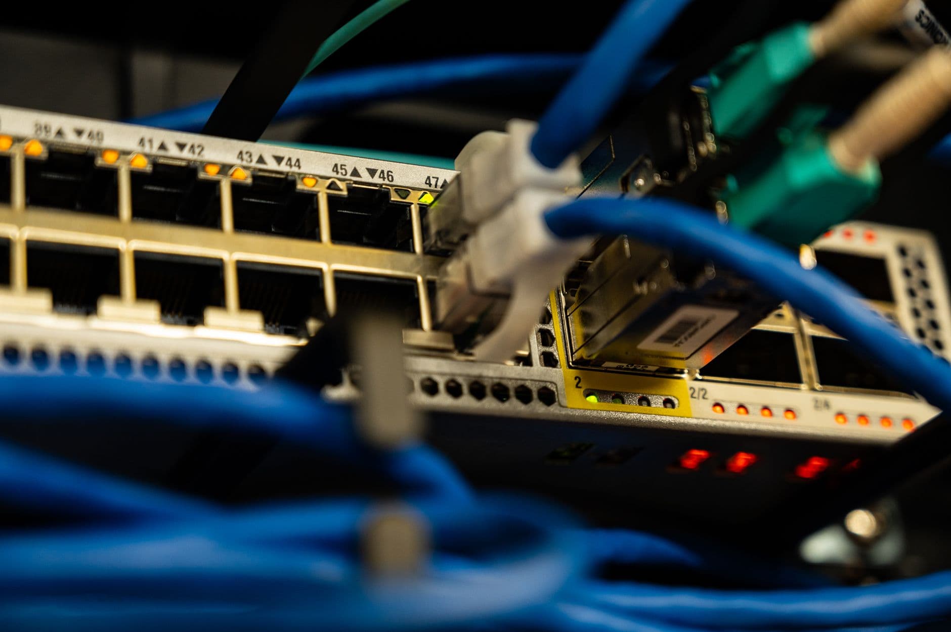 Dedicated Servers for SaaS Companies — Close-up image of ethernet cables plugged into a network switch, showcasing IT infrastructure.