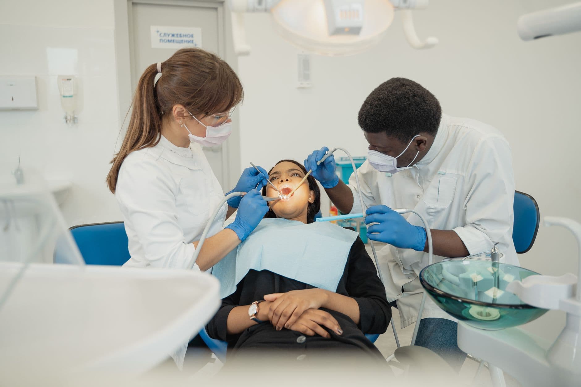 Dentist Appointment Websites — Two dental professionals treat a patient in a modern clinic setting.