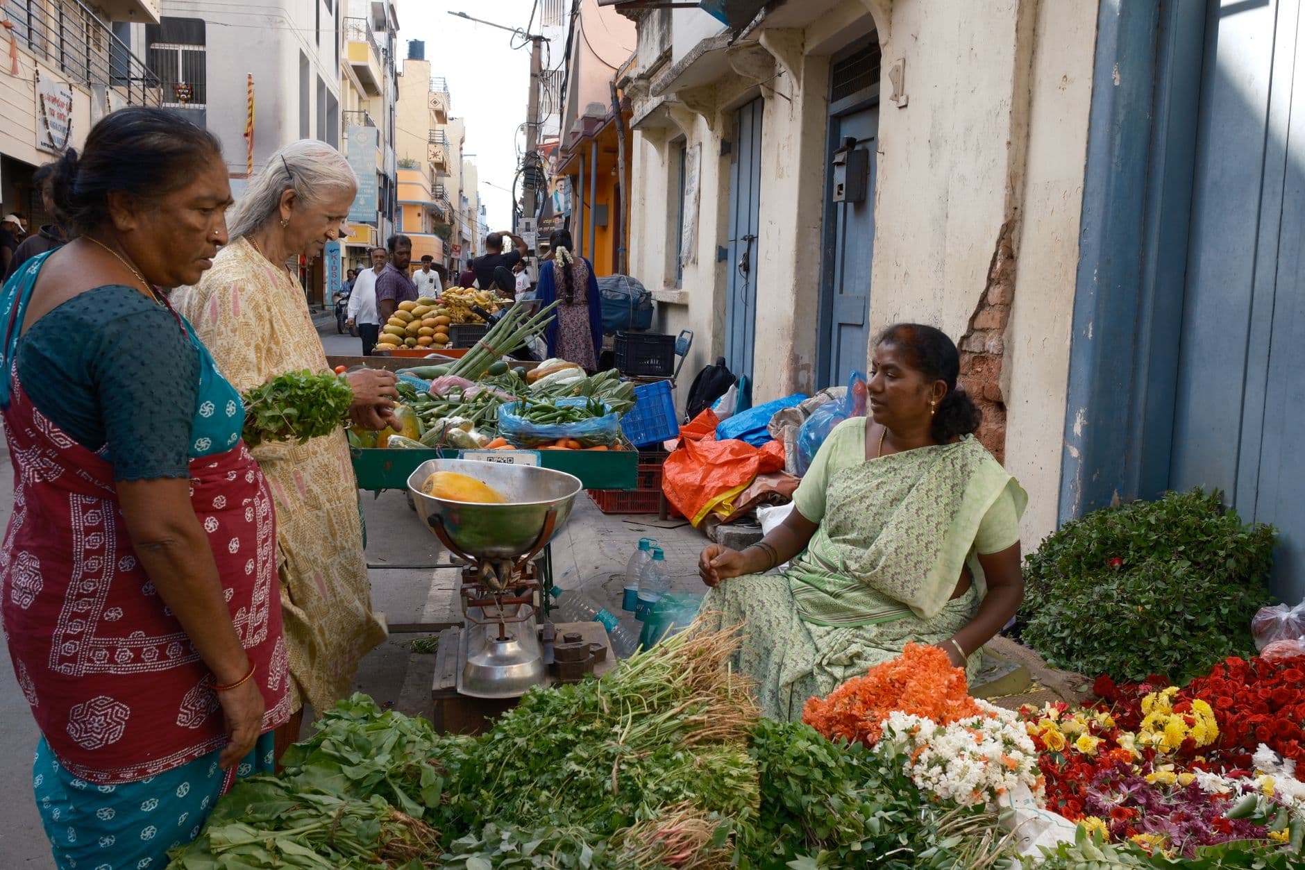 Grocery & Quick Commerce Websites — Women shopping at a vibrant street market in Bengaluru, India.