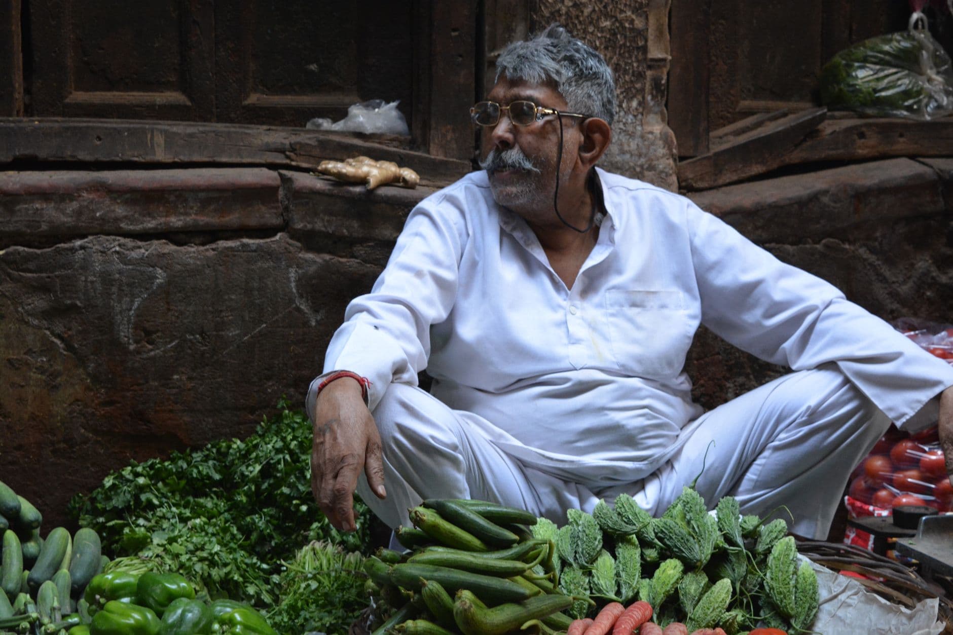 Grocery & Quick Commerce Websites — South Asian man selling fresh vegetables in Old Delhi, India.