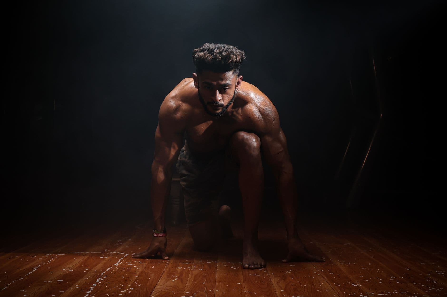 Gym & Fitness Websites — Dynamic image of a muscular man in a kneeling start position, highlighting strength and focus.