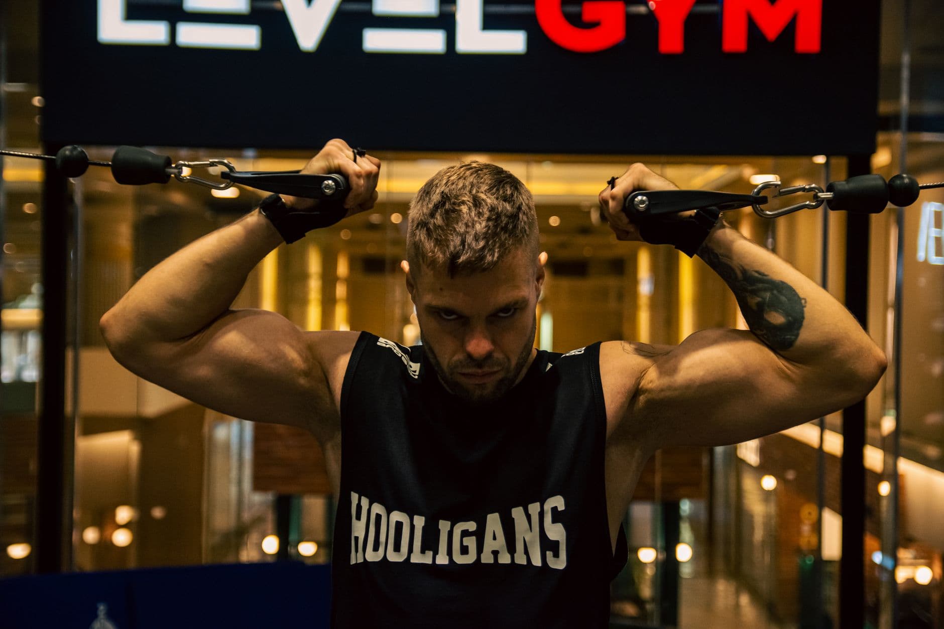 Gym & Fitness Websites — A muscular man exercises with gym equipment indoors, showcasing strength and determination.