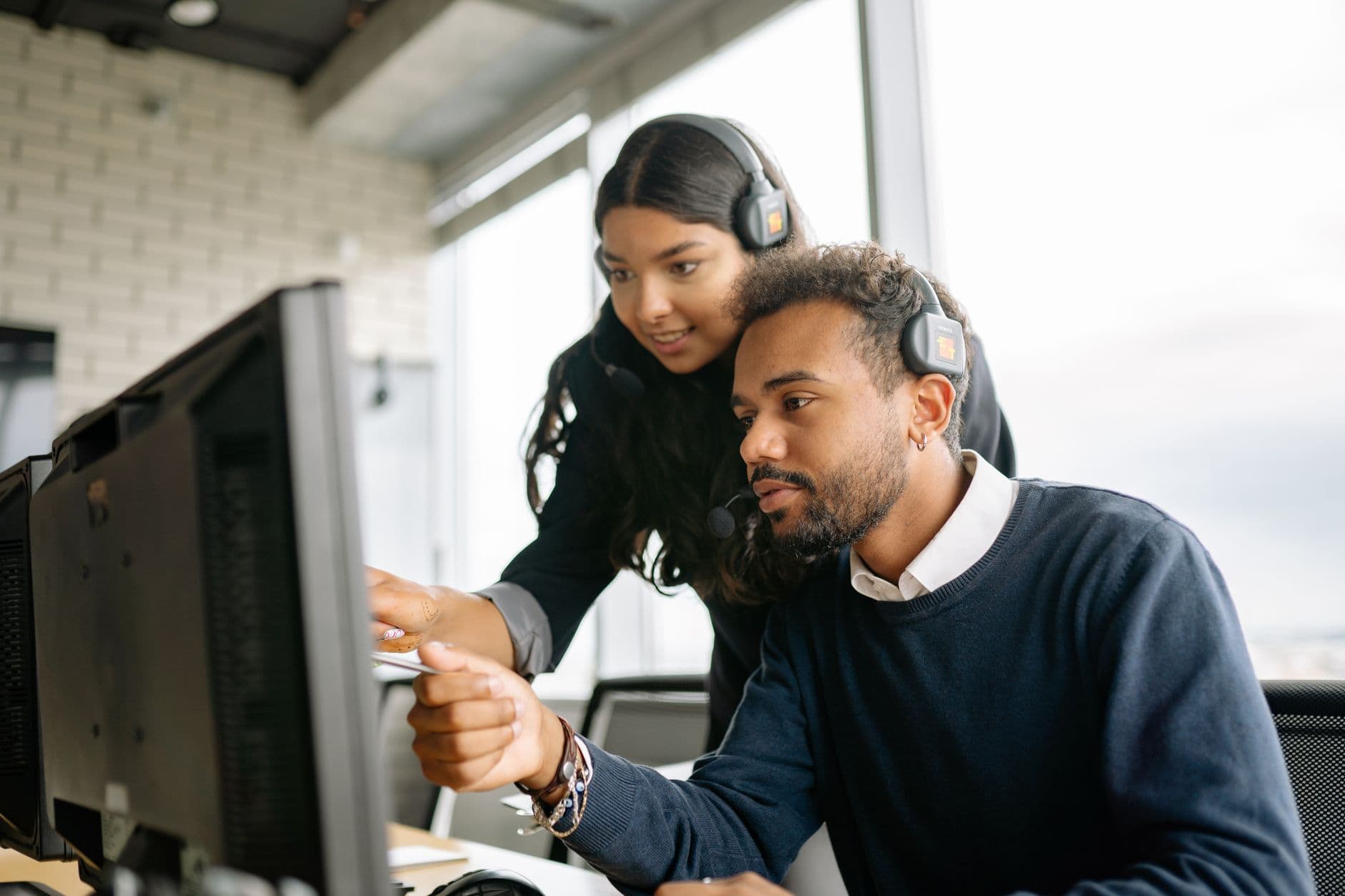 RDS Solutions for Call Centres & Software Teams — Two call center employees working together with headsets in a modern office setting.