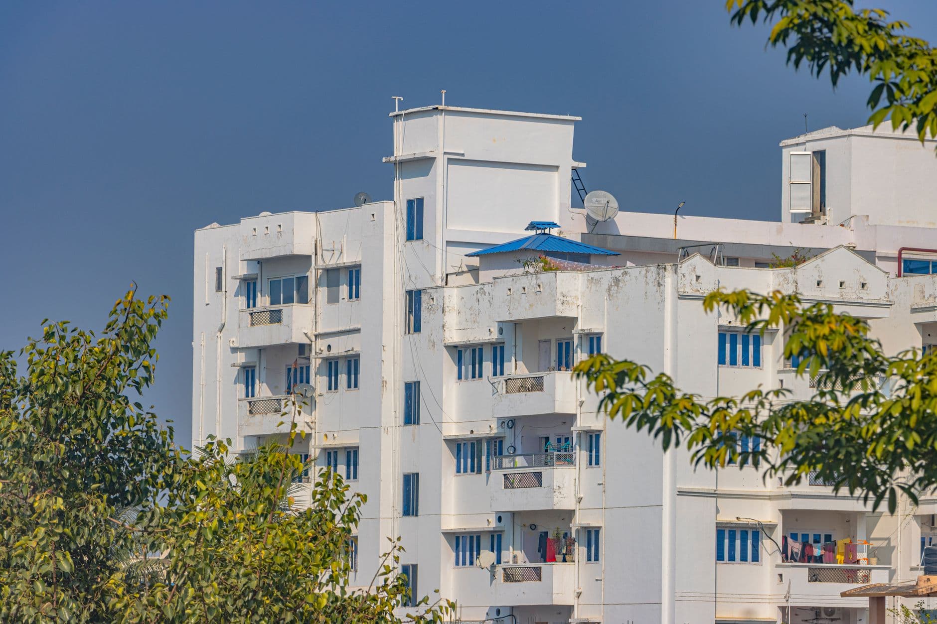 Real Estate Websites — A modern white residential building with vibrant blue windows in Hazaribagh, Jharkhand, India.