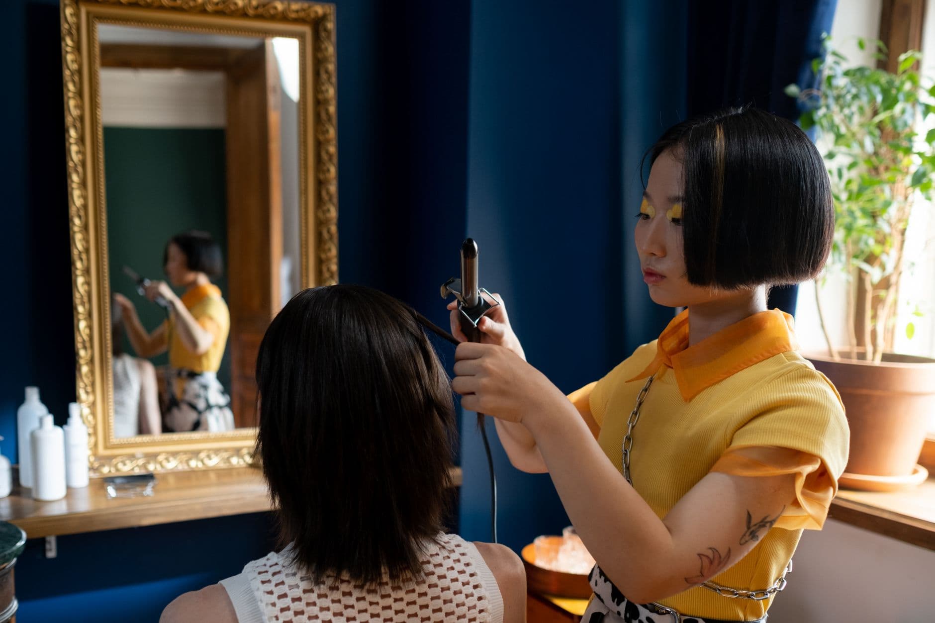Salon Appointment Websites — Hairdresser styling client's hair in a chic salon with a focus on detailed hair work.