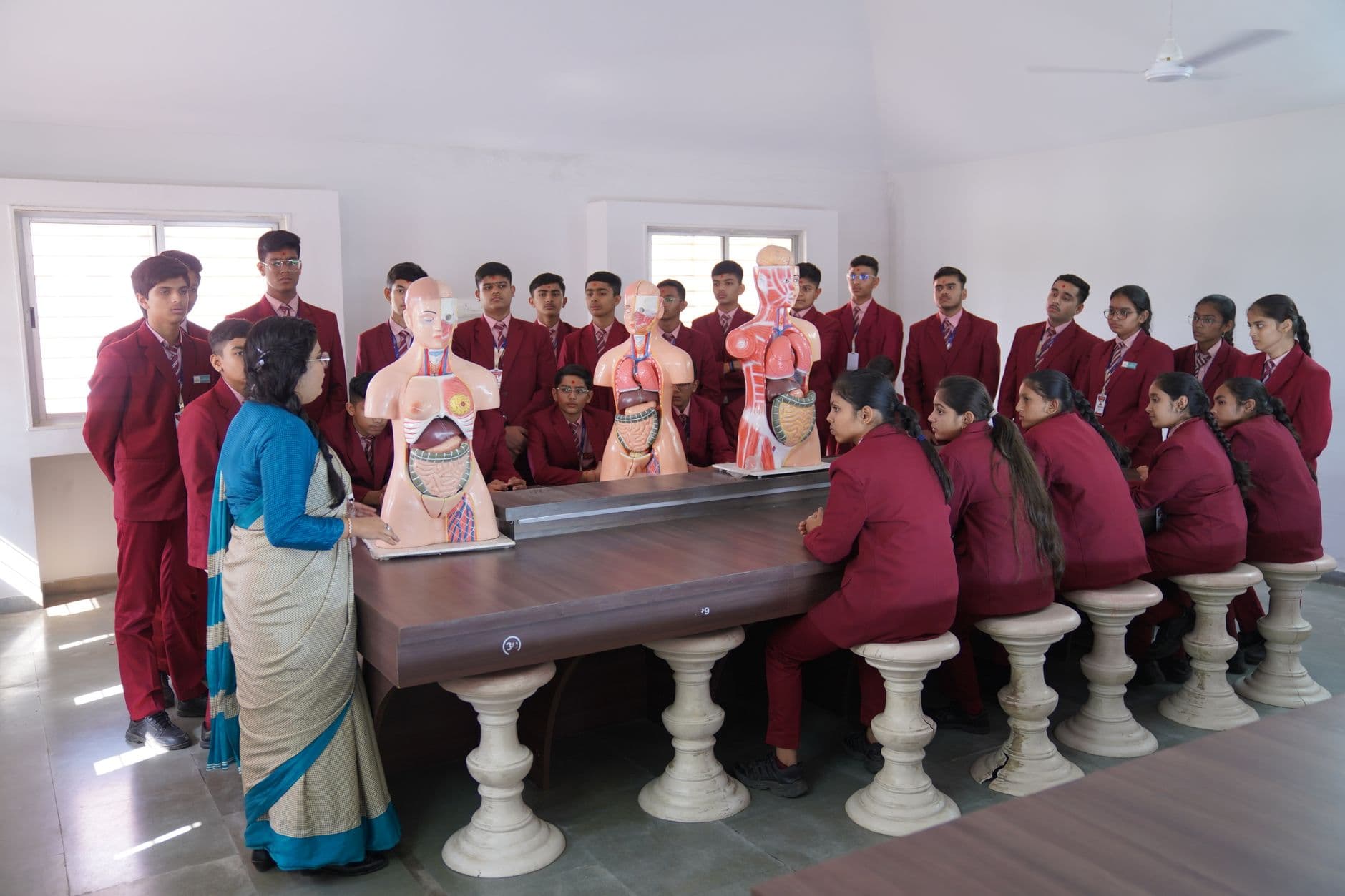 School & College Websites with Management Systems — Students in Petlad, India studying anatomy with models in a classroom.