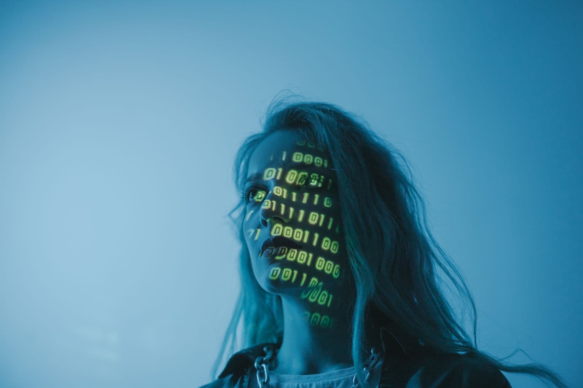 VPS Hosting for AI Startups — A woman with binary code lights projected on her face, symbolizing technology.