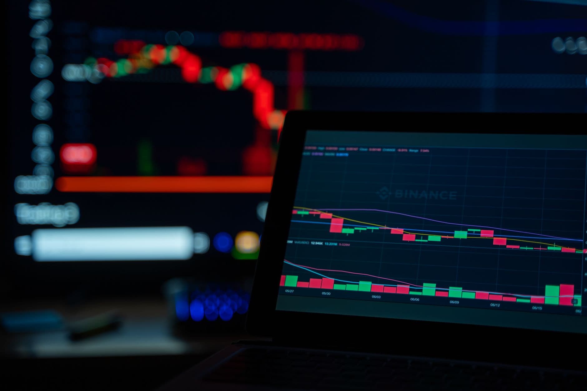 VPS Hosting for Forex Trading — A dimly lit desk setup displaying cryptocurrency trading charts on multiple screens.