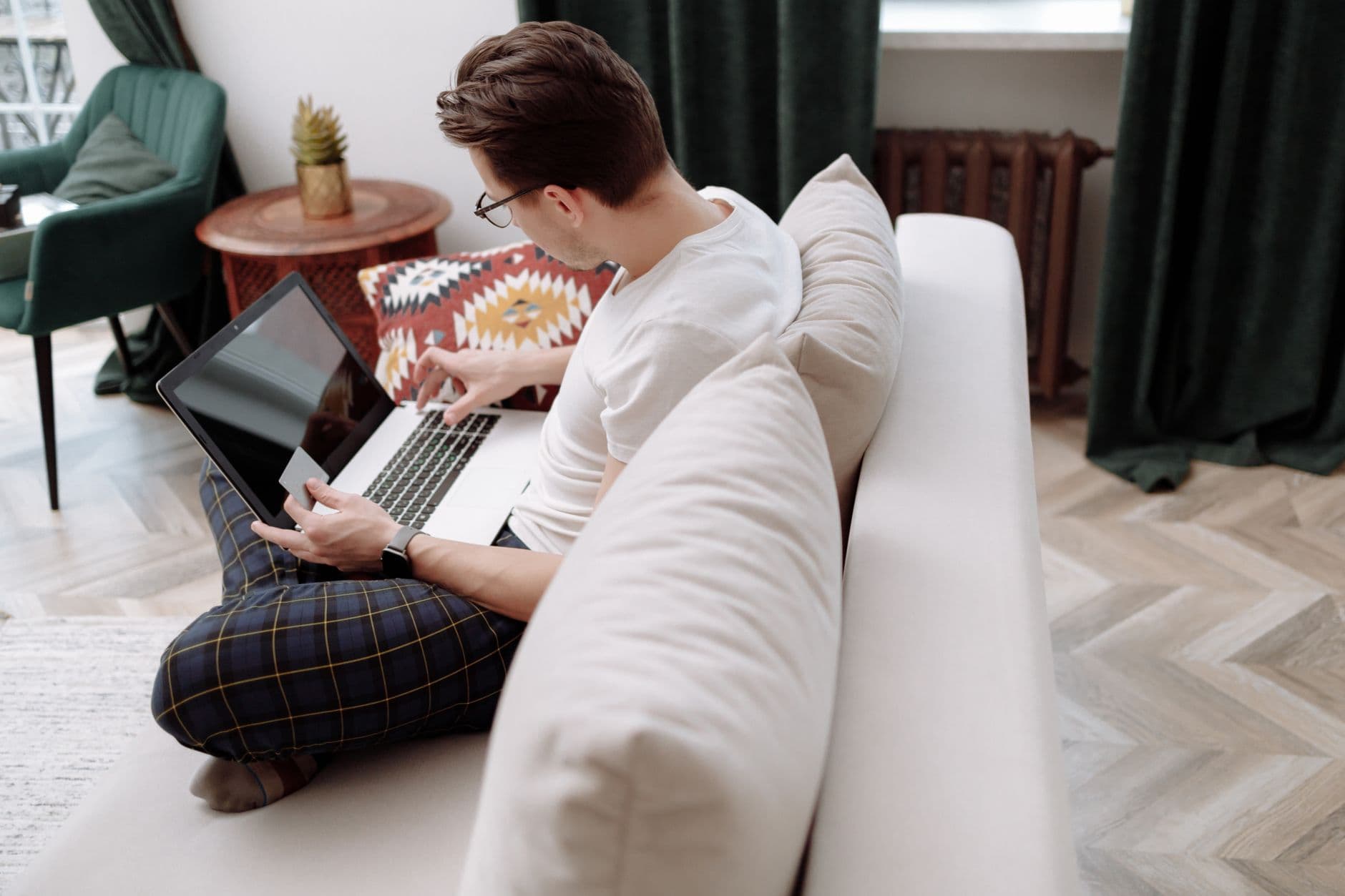 VPS Hosting for Freelancers — Man working on a laptop while sitting on a comfortable sofa in a modern, stylish room.