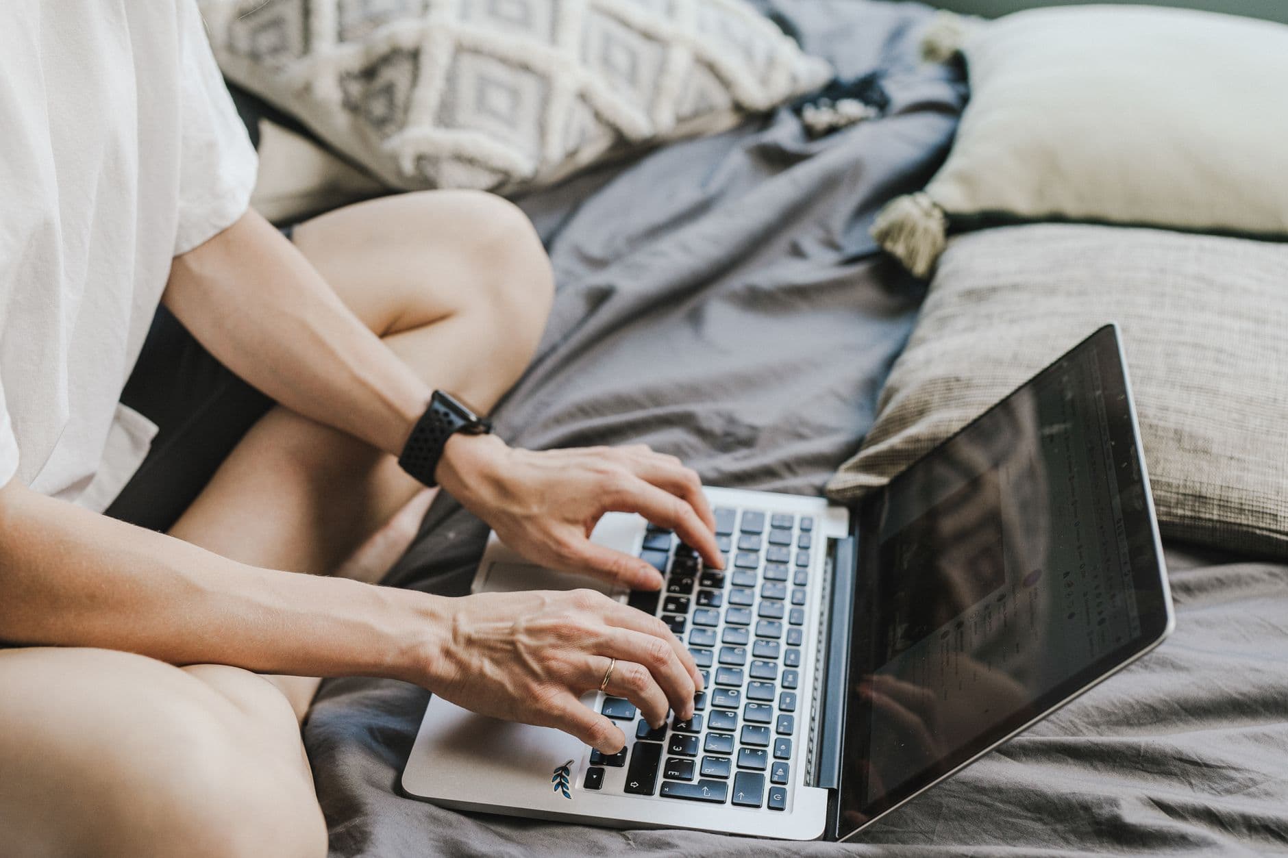 VPS Hosting for Freelancers — Person working on a laptop while sitting on a bed, showcasing a home office lifestyle.