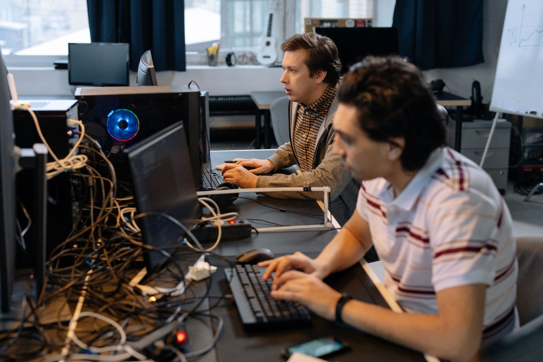 VPS Hosting for Software Companies — Male programmers working on computers in a modern office setting, showcasing teamwork and technology.