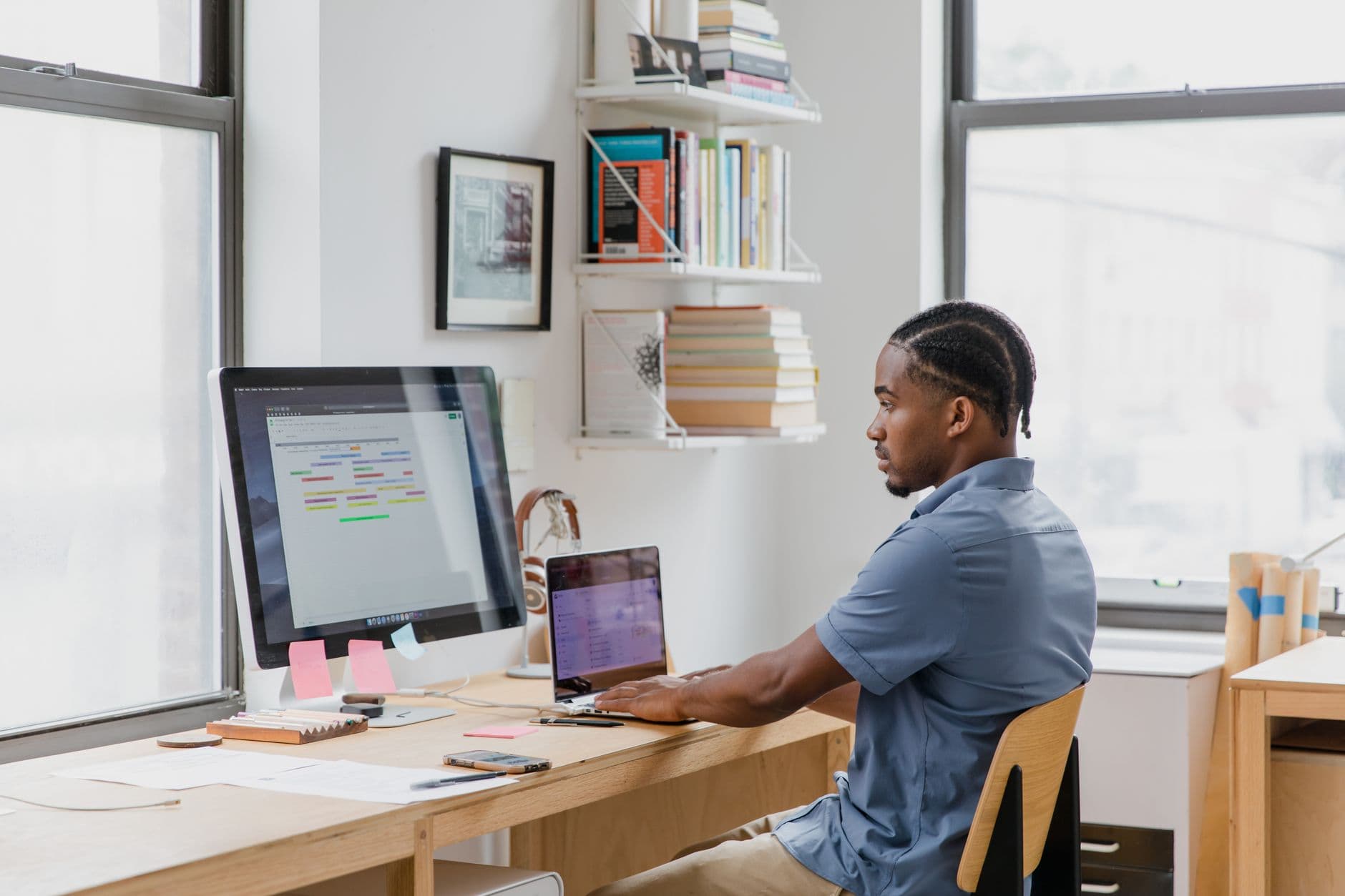 Business Automation — Focused man at home office desk working on dual screens. Ideal for remote work themes.