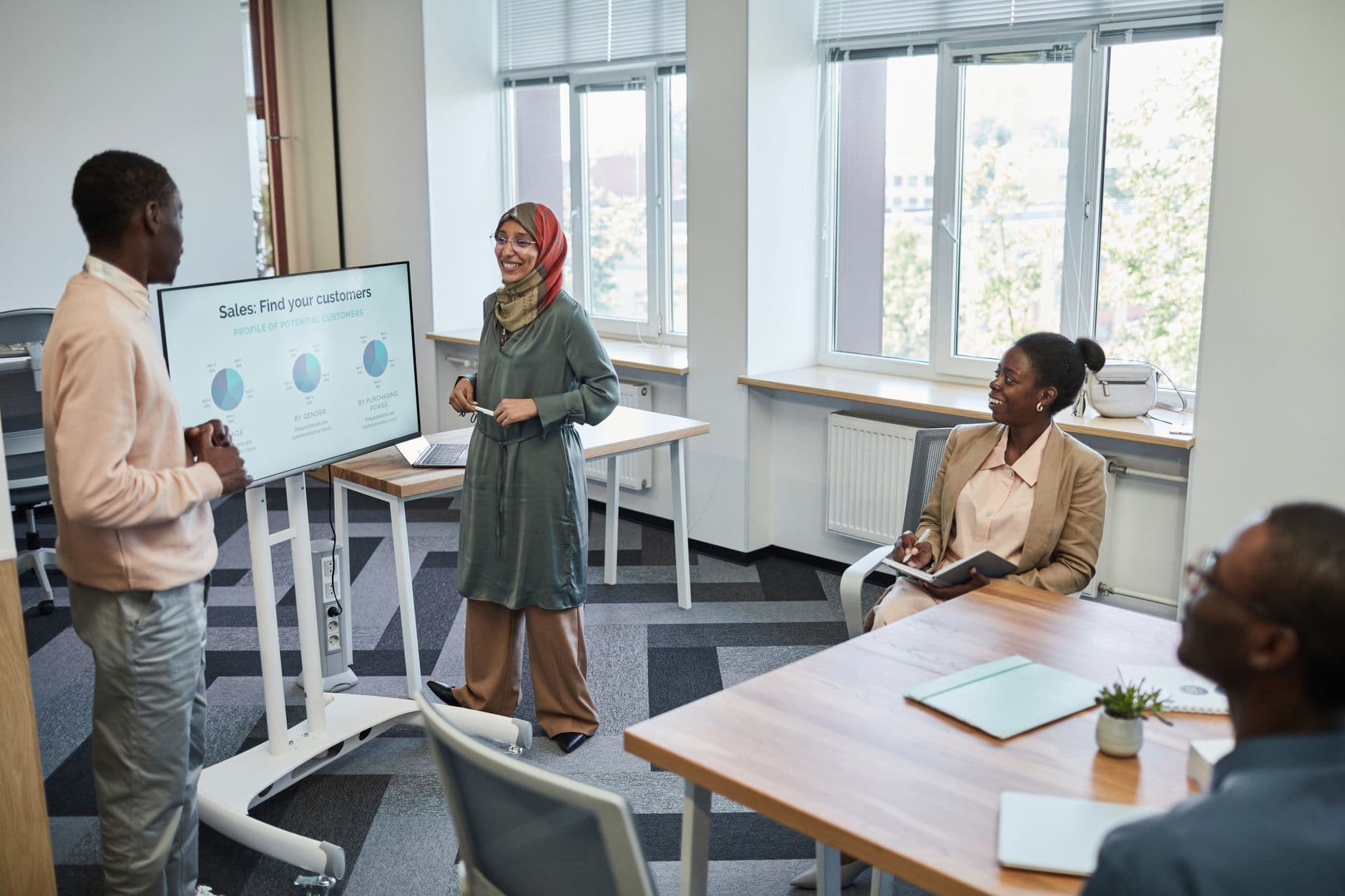 CRM Solutions — Multicultural team having a business presentation in a modern office setting.