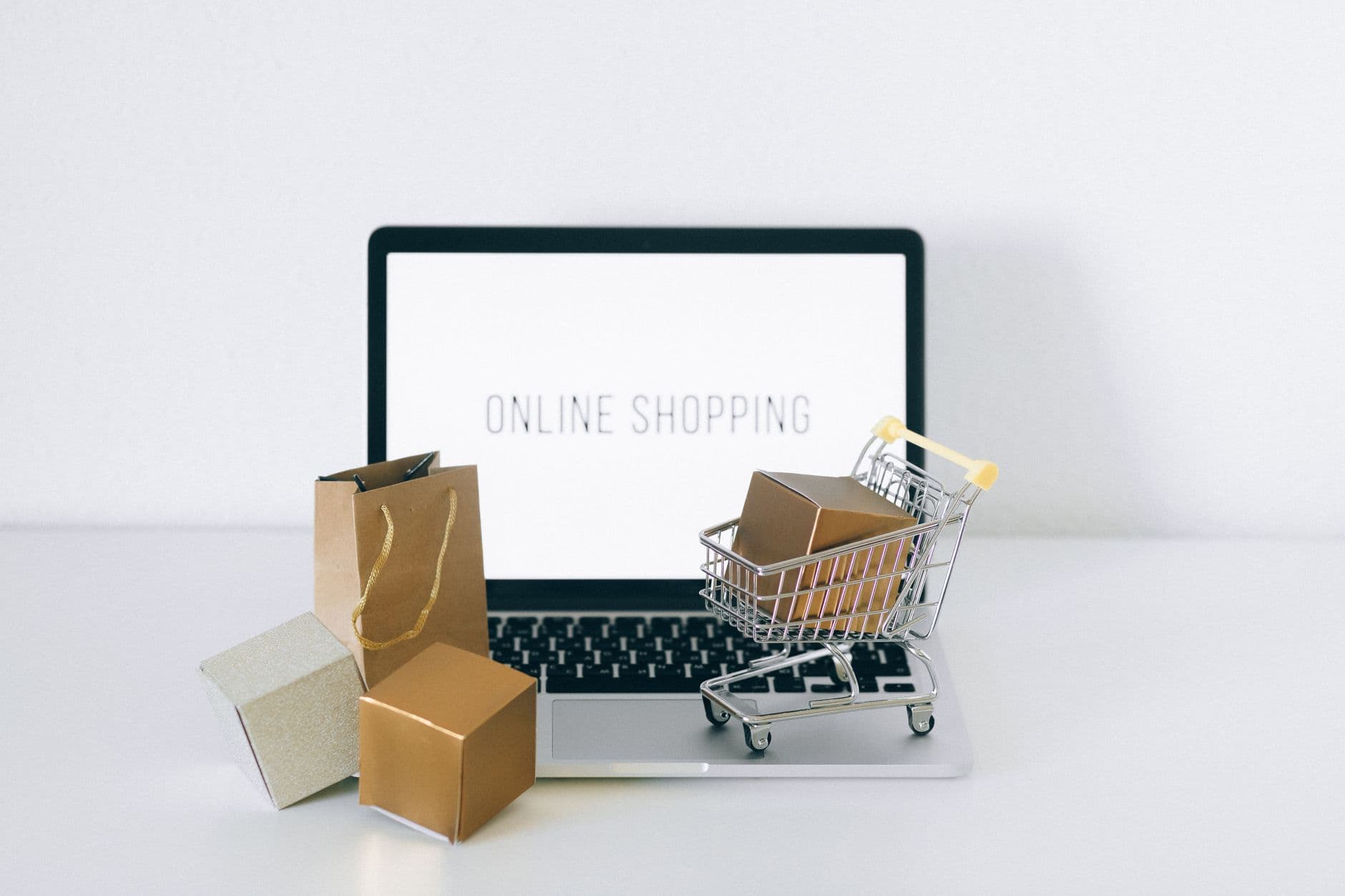 E-commerce Development — Laptop displaying online shopping with boxes and cart, representing ecommerce.