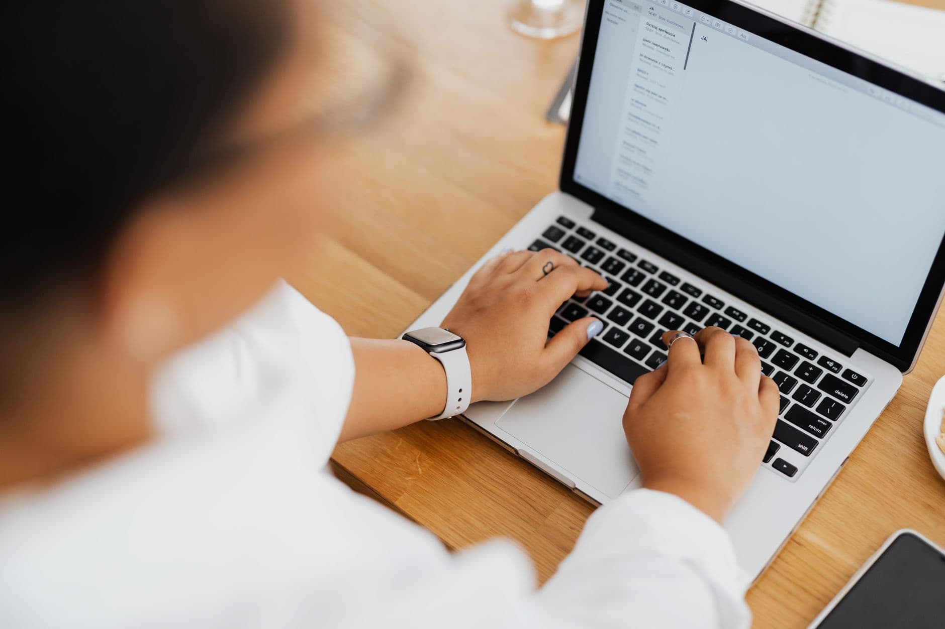 Email Marketing — High angle shot of a person typing on a laptop, focused on hands and keyboard.