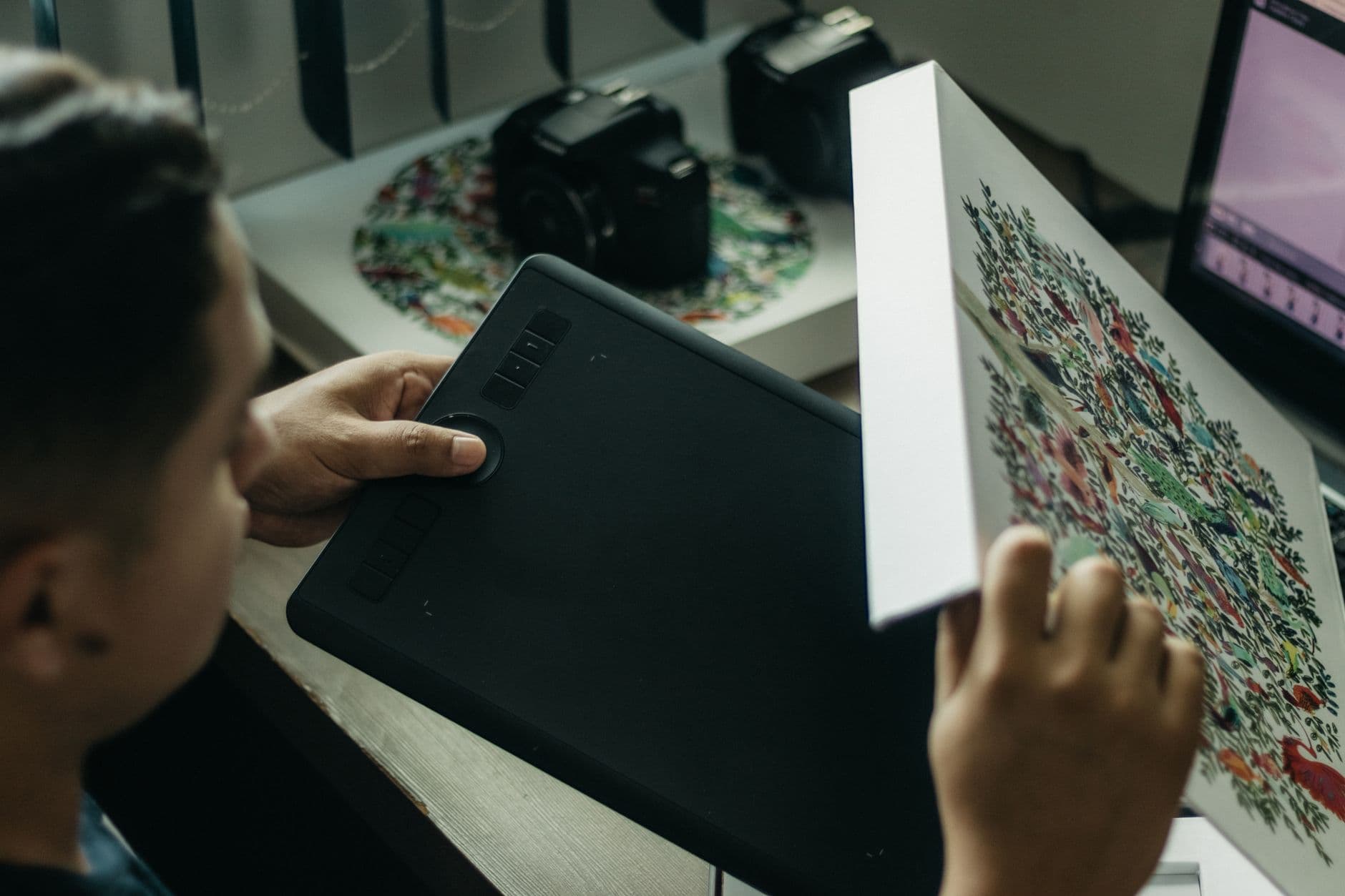 Graphic Design — Close-up of a digital artist working with a graphics tablet indoors.