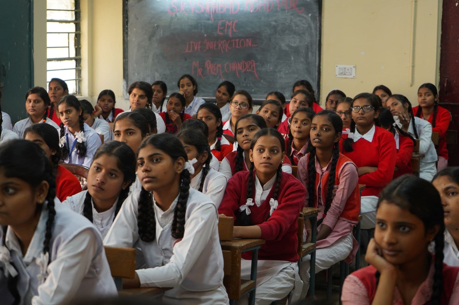 School & College Websites with Management Systems — Group of Indian schoolgirls in uniform attentively listening in a classroom setting.