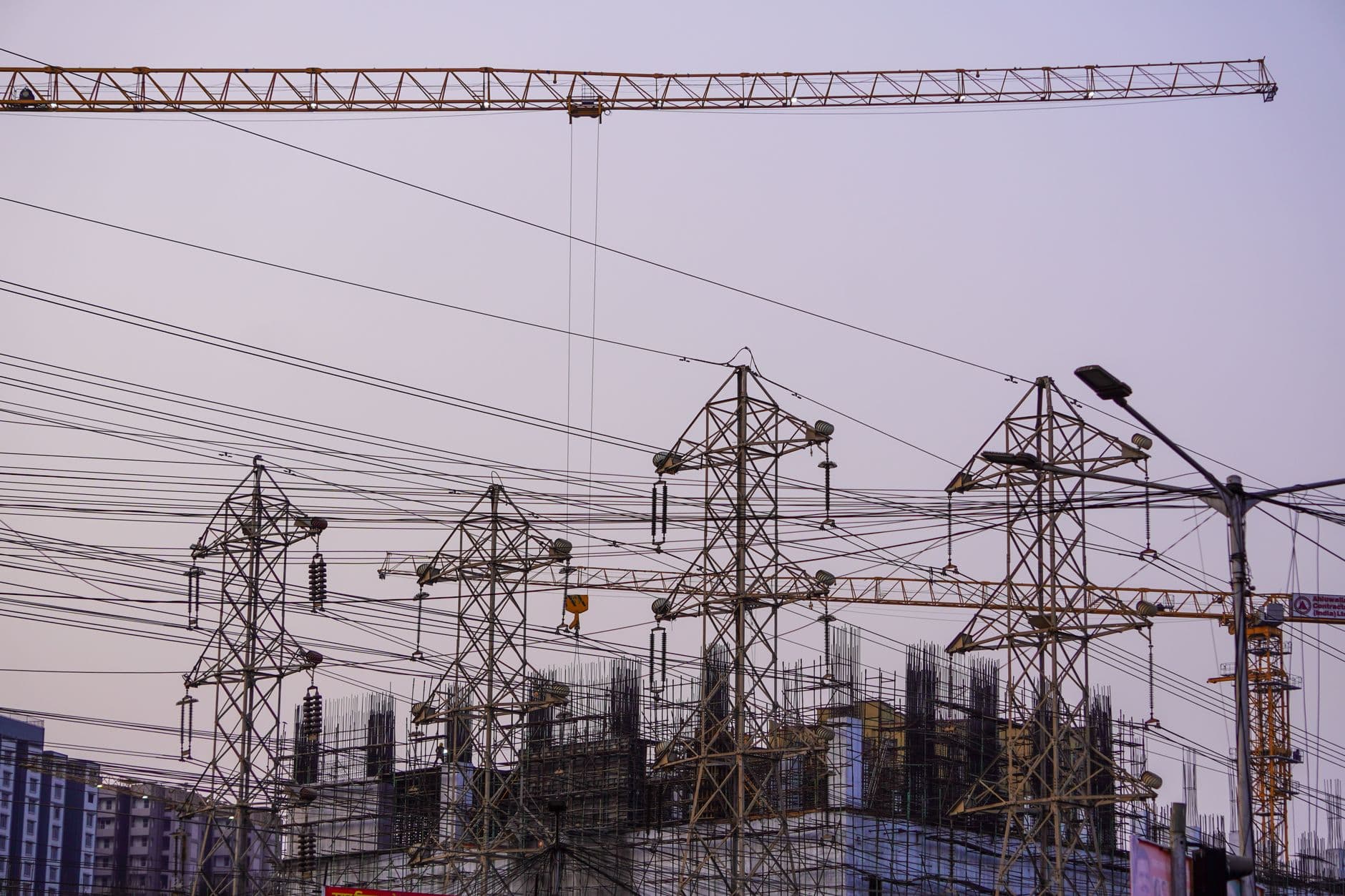Website & Hosting for Builders — Construction site with cranes and power lines in Mumbai during evening hours.