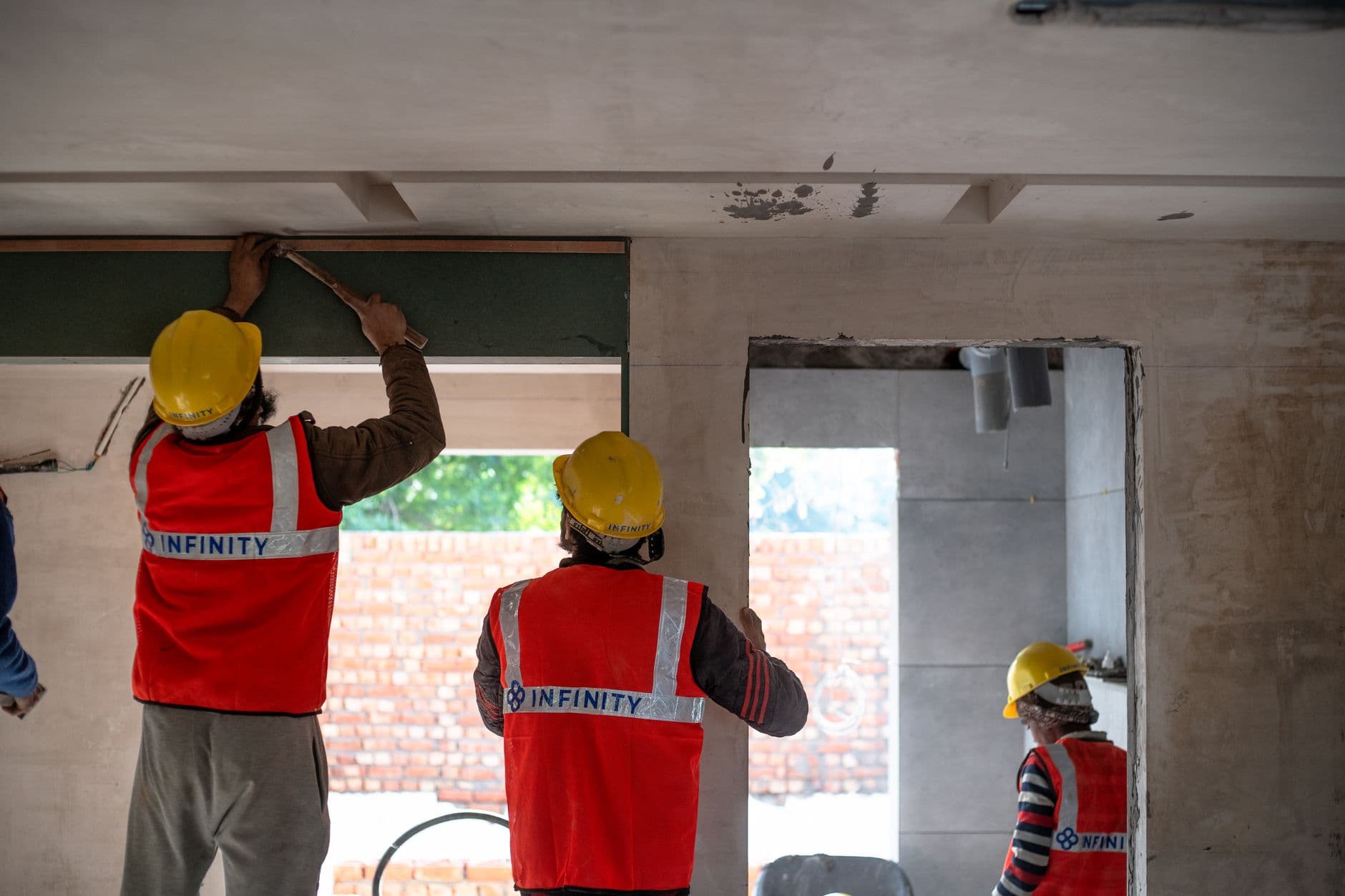 Website & Hosting for Builders — Construction workers renovating interior space in Delhi with safety gear and tools.