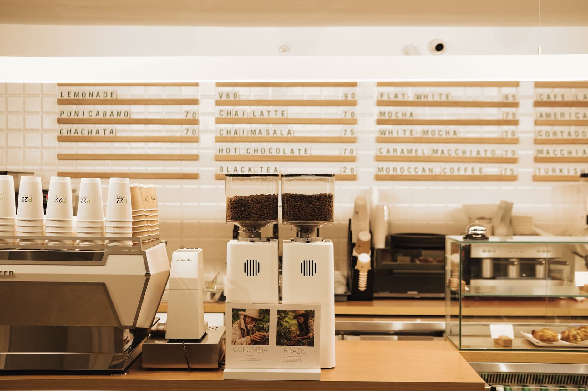 Website & Hosting for Cafes — A cozy café counter featuring coffee machines, grinders, and a menu board.