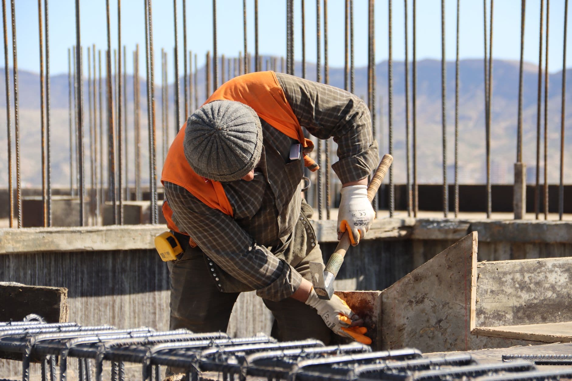 Website & Hosting for Contractors — A construction worker in safety gear working at a sunlit site with mountains in background.