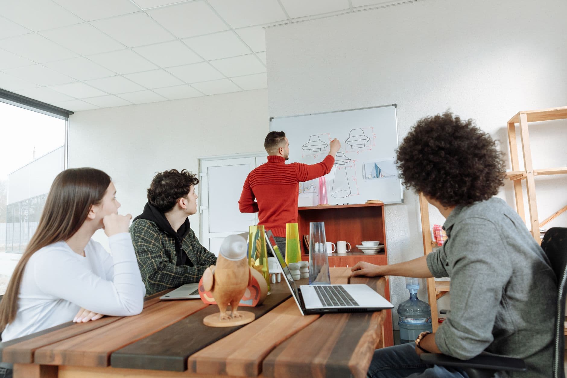 Website & Hosting for Startups — Group of young adults collaborating on design ideas in a modern office setting.